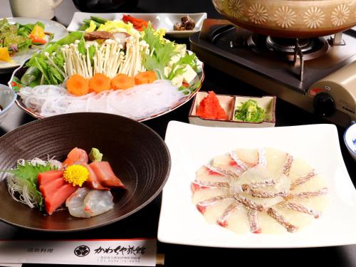 a table with three bowls of food on a stove at Kawachiya Ryokan in Minamiise