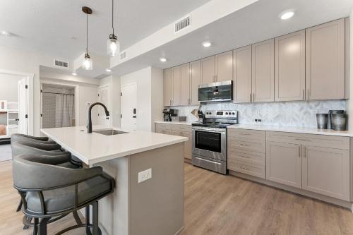 een keuken met witte kasten, een wastafel en een aanrecht bij View to Renew condo in St. George