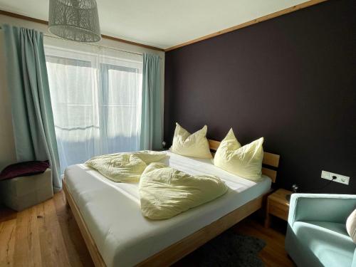 - une chambre avec un lit doté de draps et d'oreillers blancs dans l'établissement Traumblick Dachstein, à Radstadt