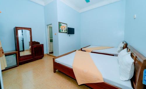een slaapkamer met een bed en een spiegel bij Nhà Nghỉ Duy Tân in Sầm Sơn
