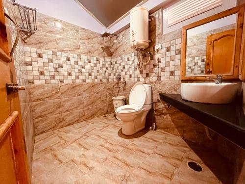 a bathroom with a toilet and a sink at The Four Season Hotel & Resort, Manali in Manāli