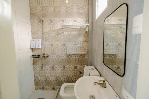 a bathroom with a sink and a toilet and a mirror at Bellissimo Minolos in Barili