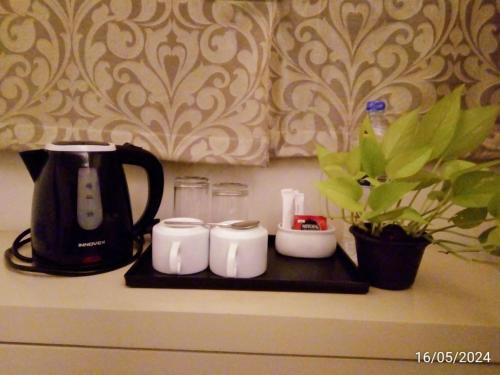 a kitchen counter with a coffee maker and three cups at Nilakma Lagoon in Negombo