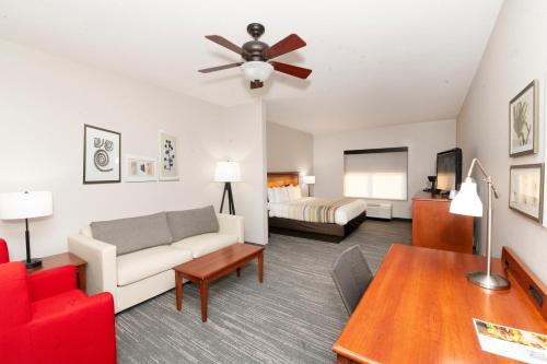 a living room with a couch and a bed at Country Inn & Suites by Radisson, Harrisburg - Hershey West, PA in Harrisburg