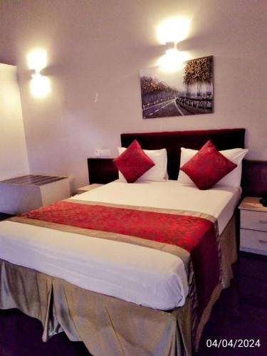 a hotel room with a large bed with red pillows at Nilakma Lagoon in Negombo