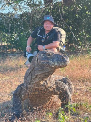 a boy sitting on top of a statue of an alligator at Jhuna Komodo Homestay in Komodo
