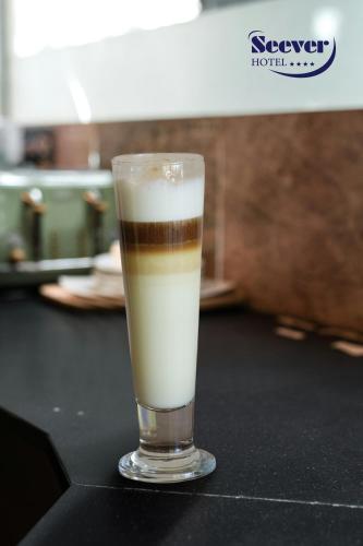 a drink in a glass sitting on a table at Hotel Seever in Erbil