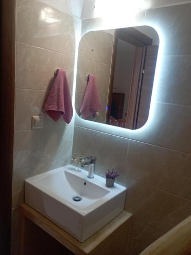 y baño con lavabo blanco y espejo. en Akrogiali Rooms & Studios, en Drymonas