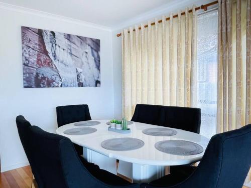 a dining room table with chairs and a white table at Glengala D134 Glengala Best West in Ardeer