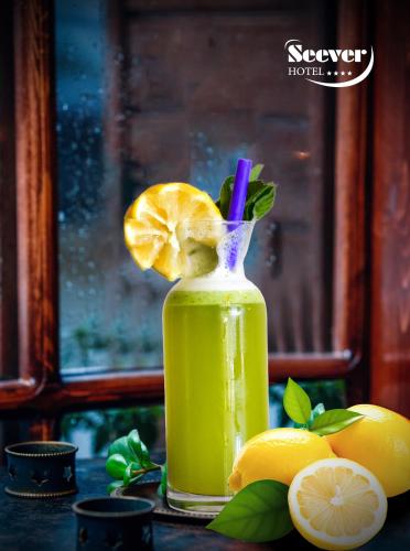 a bottle of lemon juice sitting on a table with lemons at Hotel Seever in Erbil