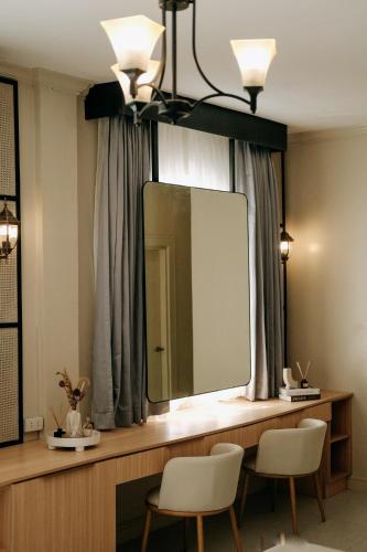 a mirror on a counter with two chairs in a room at Bellissimo Minolos in Barili