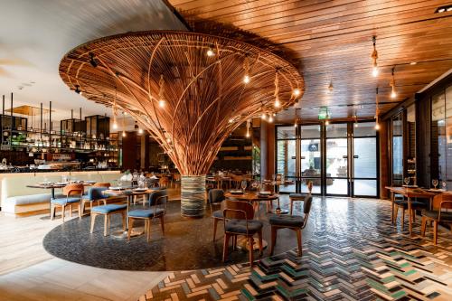 a restaurant with wooden ceilings and tables and chairs at Hotel Indigo Phuket Patong by IHG in Patong Beach