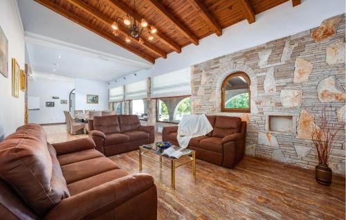 a living room with leather furniture and a stone wall at Villa Casa Travertina in Ruhci