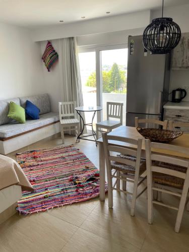 a living room with a table and a kitchen at Kostas Studios in Faliraki