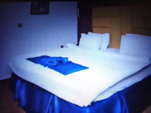 a white bed with a blue picture on it at Villa toscana okpanam Rd Asaba in Okpanam