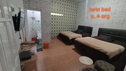 a living room with beds and a tv in it at DIENG GHUZY HOUSE syariah twin bed in Dieng