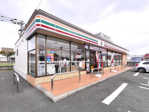 a store with glass windows in a parking lot at Vessel Hotel Kumamoto Airport in Ozu