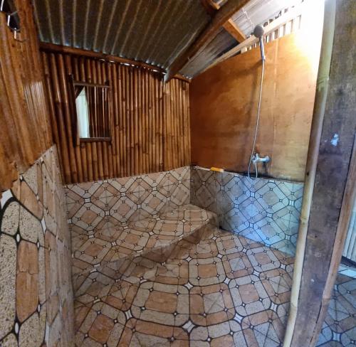 uma casa de banho com um chuveiro num edifício de madeira em Tetebatu Hostel em Tetebatu