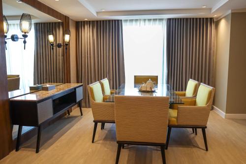 une salle à manger avec une table en verre et des chaises jaunes dans l'établissement Mandarin Bay Resort and Spa, à Boracay