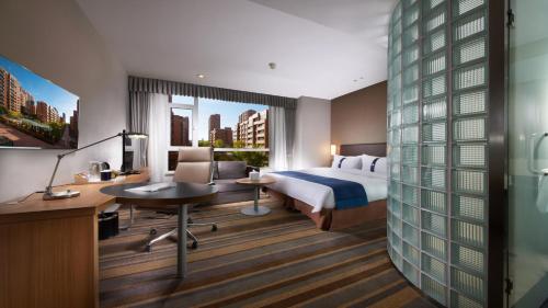 um quarto de hotel com uma cama, uma secretária e um computador em Holiday Inn Express Ordos Dongsheng, an IHG Hotel em Ordos