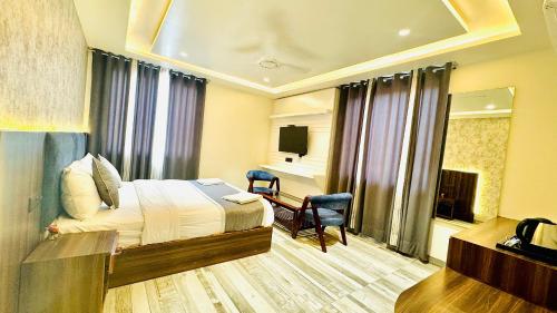 a hotel room with a bed and a television at Raksha Suites & Banquet Greater Noida in Greater Noida