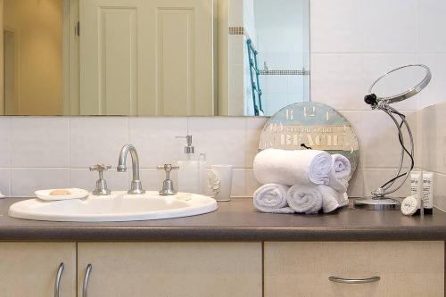 a bathroom with a sink and a mirror and towels at Escape To Narrabeen @ Sydney Northern Beaches - Home Away From Home in Narrabeen