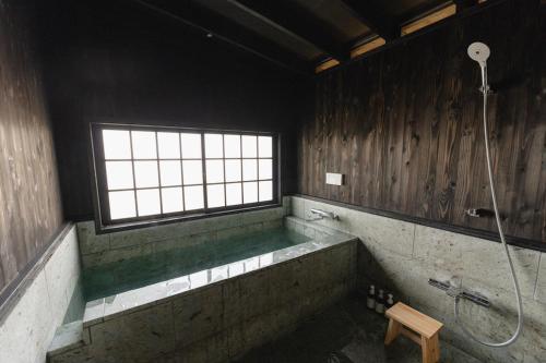 een badkamer met een bad en een raam bij Kamogawa919 in Kamogawa
