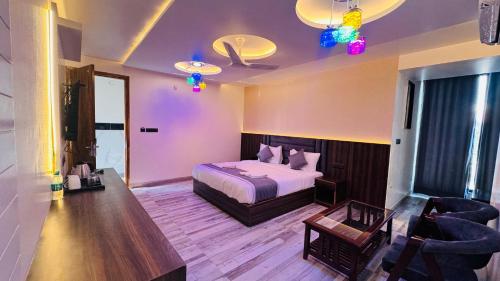 a hotel room with a bed and a table and chairs at Raksha Suites & Banquet Greater Noida in Greater Noida