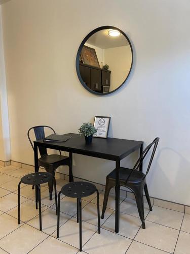 a black table with two chairs and a mirror at Villa Angel in Tijuana