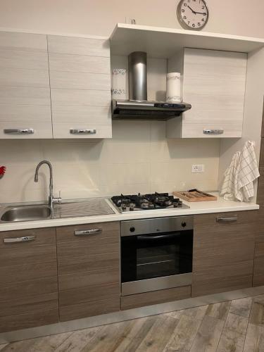 uma cozinha com um fogão, um lavatório e um relógio em BONBON em Rovigo