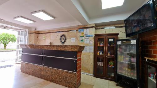 a bar in a restaurant with a counter and a tv at Gran Caribe Hotel in Medellín