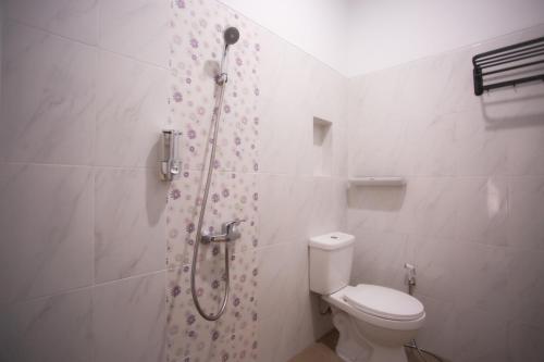 a bathroom with a shower with a toilet and a shower curtain at Fresh Inn in Probolinggo