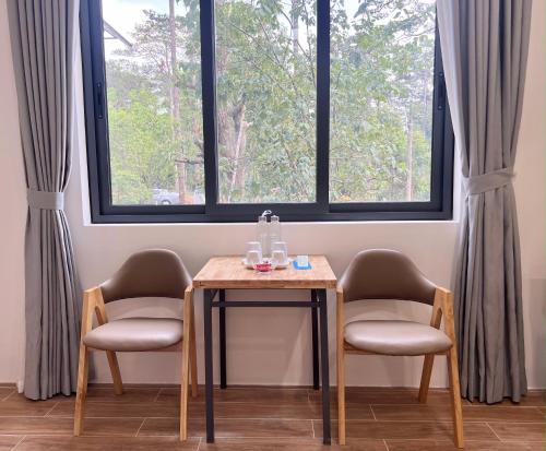 a table and two chairs in a room with two windows at Zephyrus Villa - Standard 1 in Kon Von Kla