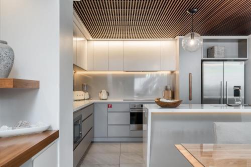a kitchen with white cabinets and white appliances at KoKo's Beach House 4 in Byron Bay