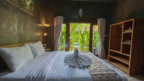 a bedroom with a bed in a room with a window at Elemento Homestay Badung in Bringkit