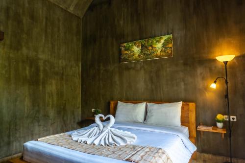 a bedroom with a bed with a swan decoration on it at Elemento Homestay Badung in Bringkit