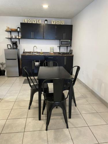 a kitchen with a black table and chairs in a room at Villa Angel in Tijuana