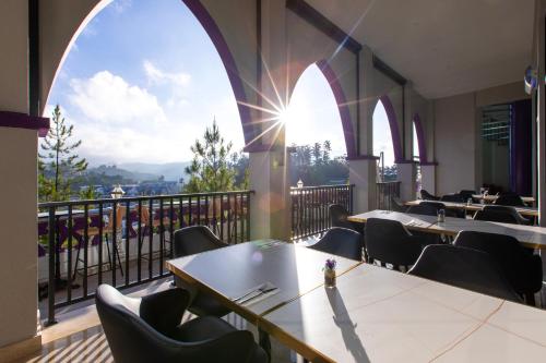 restauracja ze stołami i krzesłami oraz balkonem w obiekcie Cameron Lavender Mansion by PLAY w mieście Brinchang