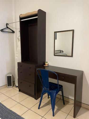 a blue chair sitting next to a desk with a mirror at Villa Angel in Tijuana