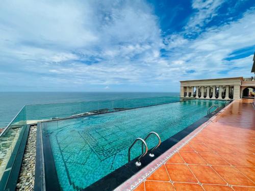 a swimming pool with the ocean in the background at Sea Gallery Phu Quoc Luxury Apartment in Phu Quoc