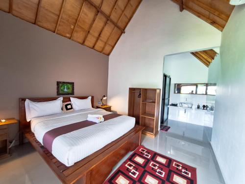 a bedroom with a bed and a large glass window at Novia Guest House Lombok-Tetebatu in Tetebatu