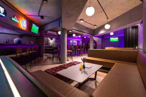a restaurant with a table and chairs and purple lights at Cameron Lavender Mansion by PLAY in Brinchang