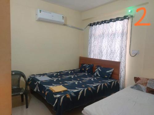 a bedroom with two beds and a window with a bed sqor at Jankivihar Homestay at Prahladghat within 1km from Shri Ram Mandir in Ayodhya