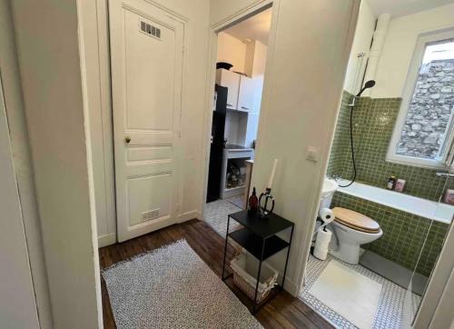 La salle de bains est pourvue d'une douche, de toilettes et d'une baignoire. dans l'établissement Cosy Haussmannien appartement, à Paris