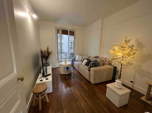 un salon avec un canapé et une table dans l'établissement Cosy Haussmannien appartement, à Paris