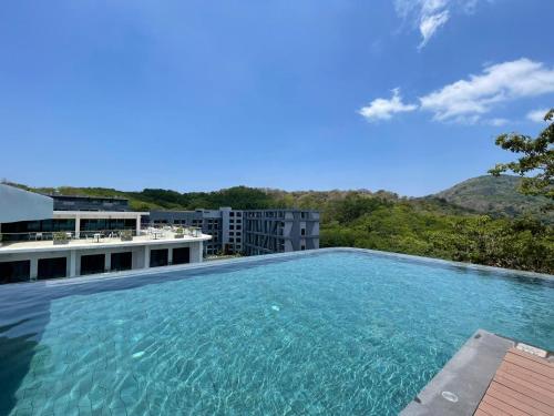 une grande piscine devant un immeuble dans l'établissement Utopia Naiharn by Fred&Com Phuket, à Rawai Beach