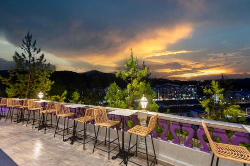 una fila di tavoli e sedie su un balcone di Cameron Lavender Mansion by PLAY a Brinchang