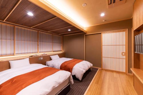 two beds in a small room with wooden walls at Uesugi no Miyu Gotenmori in Nanyo