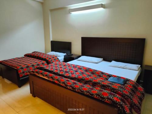 ラーワルピンディーにあるAl Sakhawat Hotelのホテルルーム内のベッド2台(毛布付)