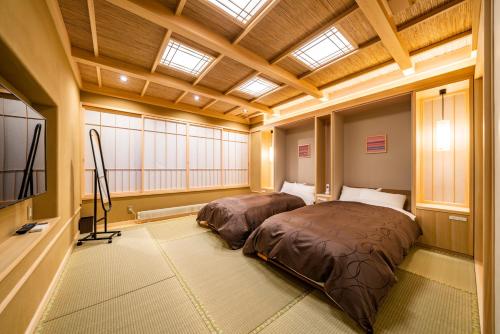 a bedroom with two beds in a room with windows at Uesugi no Miyu Gotenmori in Nanyo